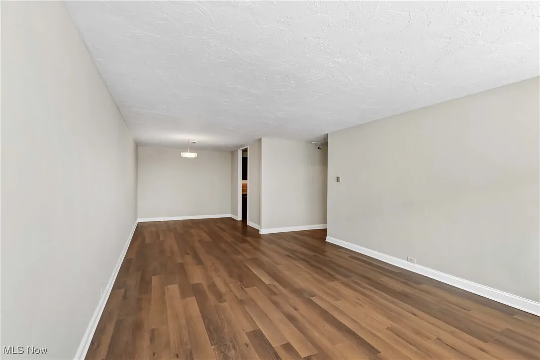 Unfurnished room featuring dark hardwood / wood-style floors and a textured ceiling