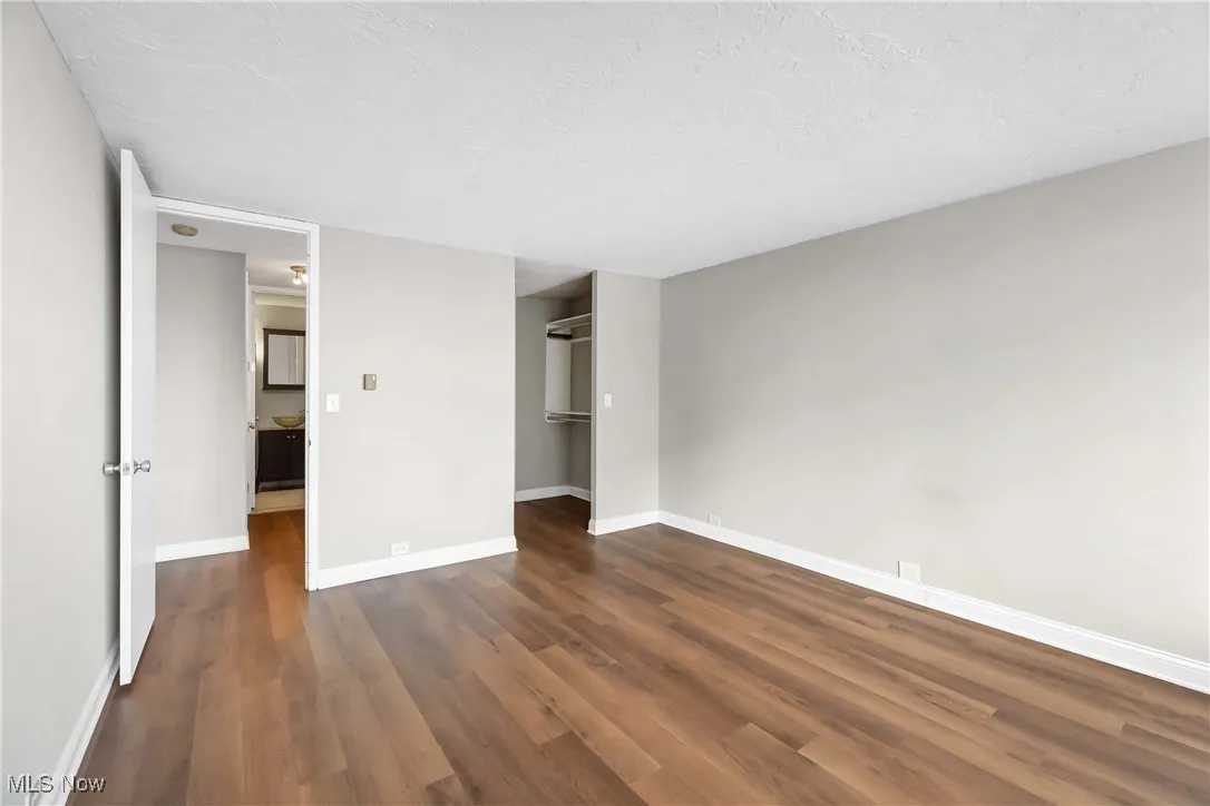 Unfurnished bedroom with dark hardwood / wood-style floors, a closet, and a textured ceiling