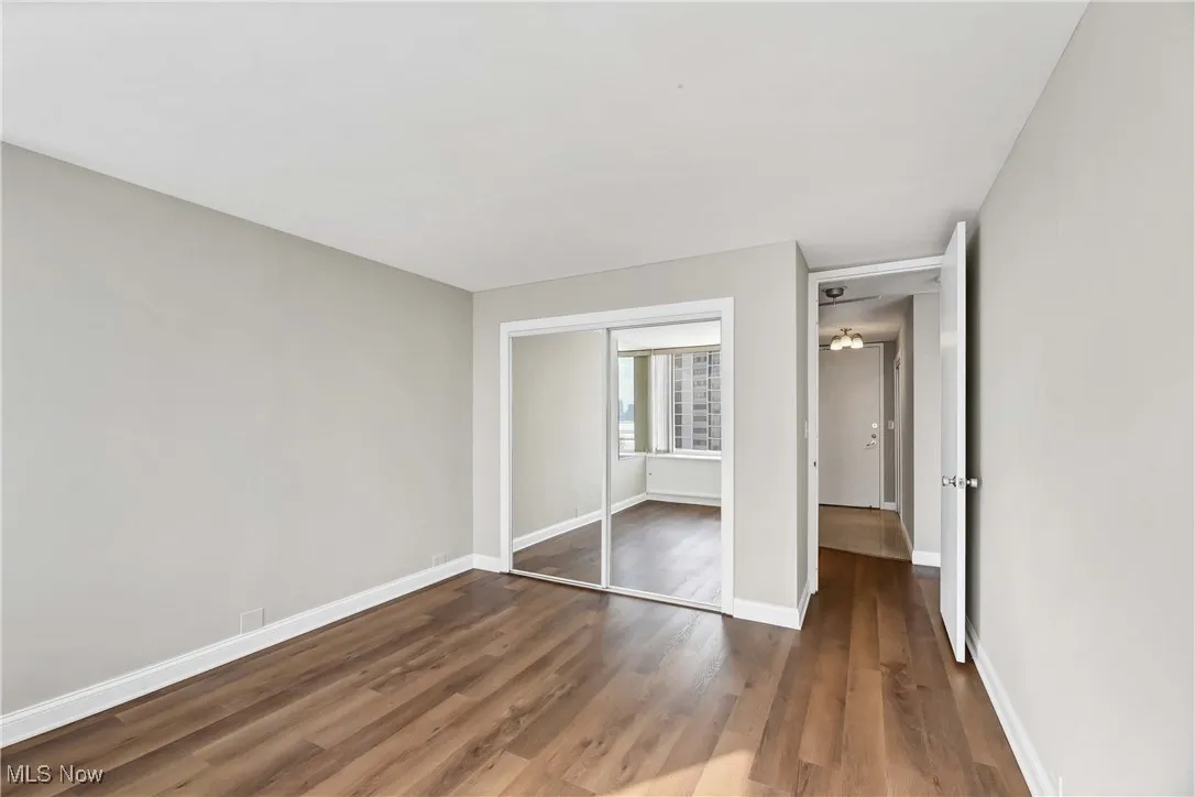 Unfurnished bedroom with dark hardwood / wood-style floors and a closet