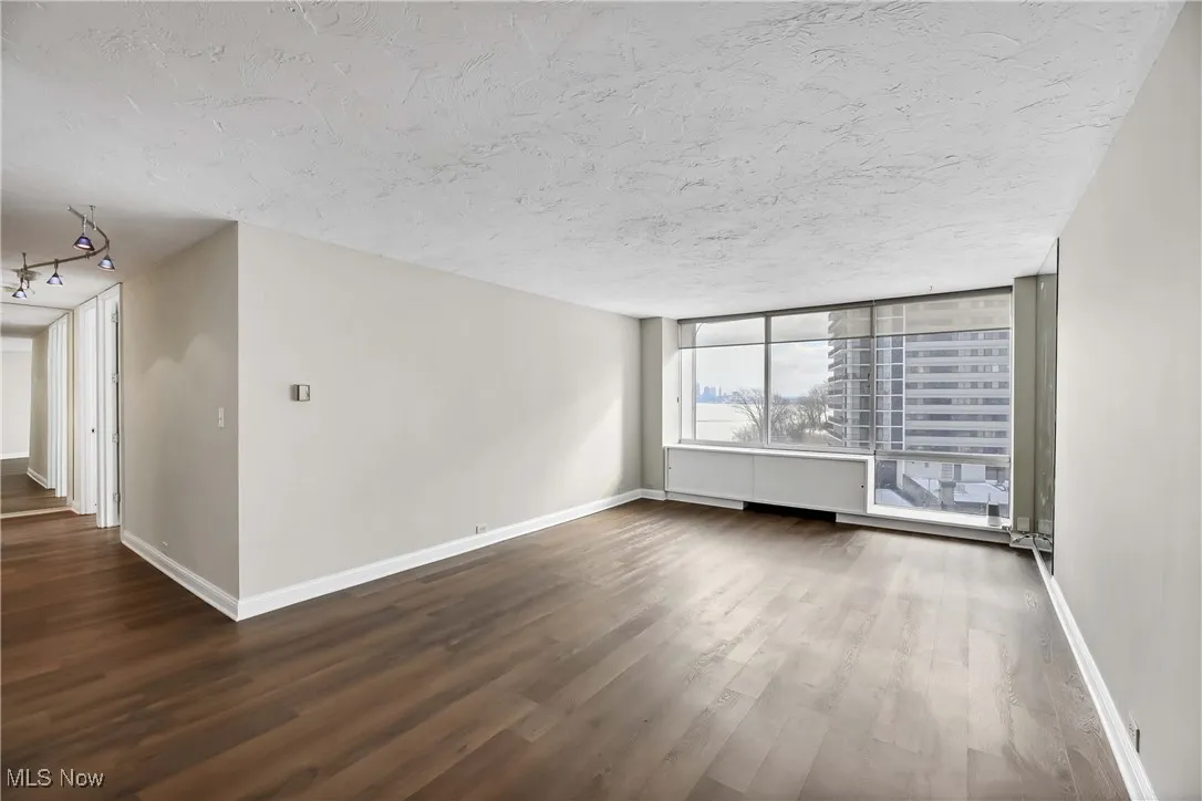 Empty room with wood-type flooring and a textured ceiling
