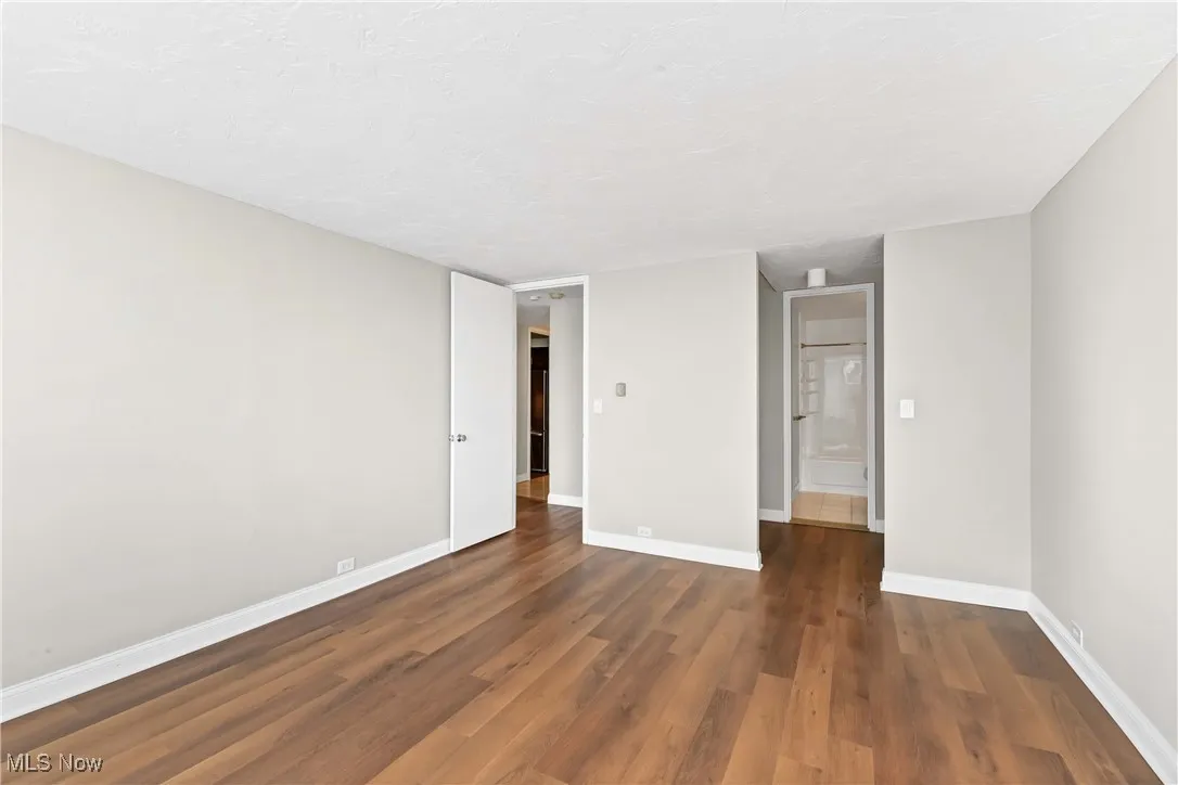Empty room with dark hardwood / wood-style flooring