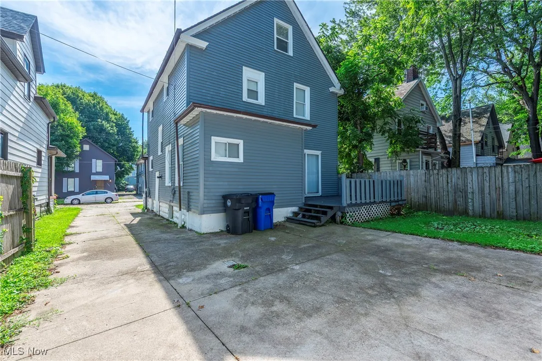 Back of house with concrete driveway and a wooden deck