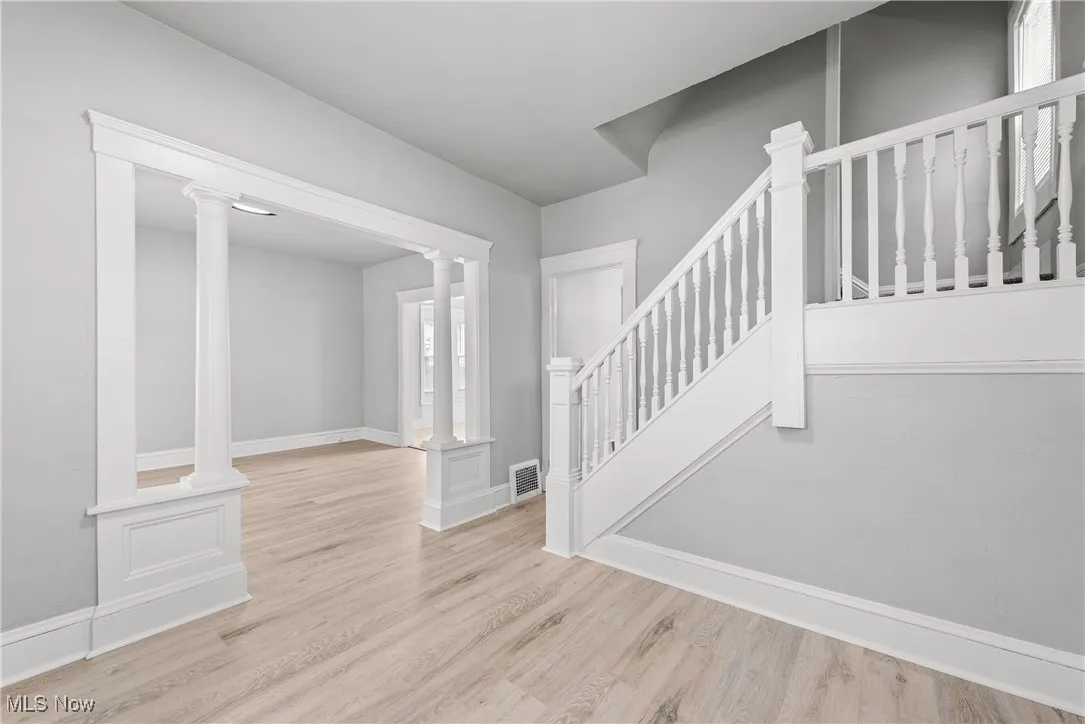 Entryway featuring light hardwood / wood-style floors and ornate columns