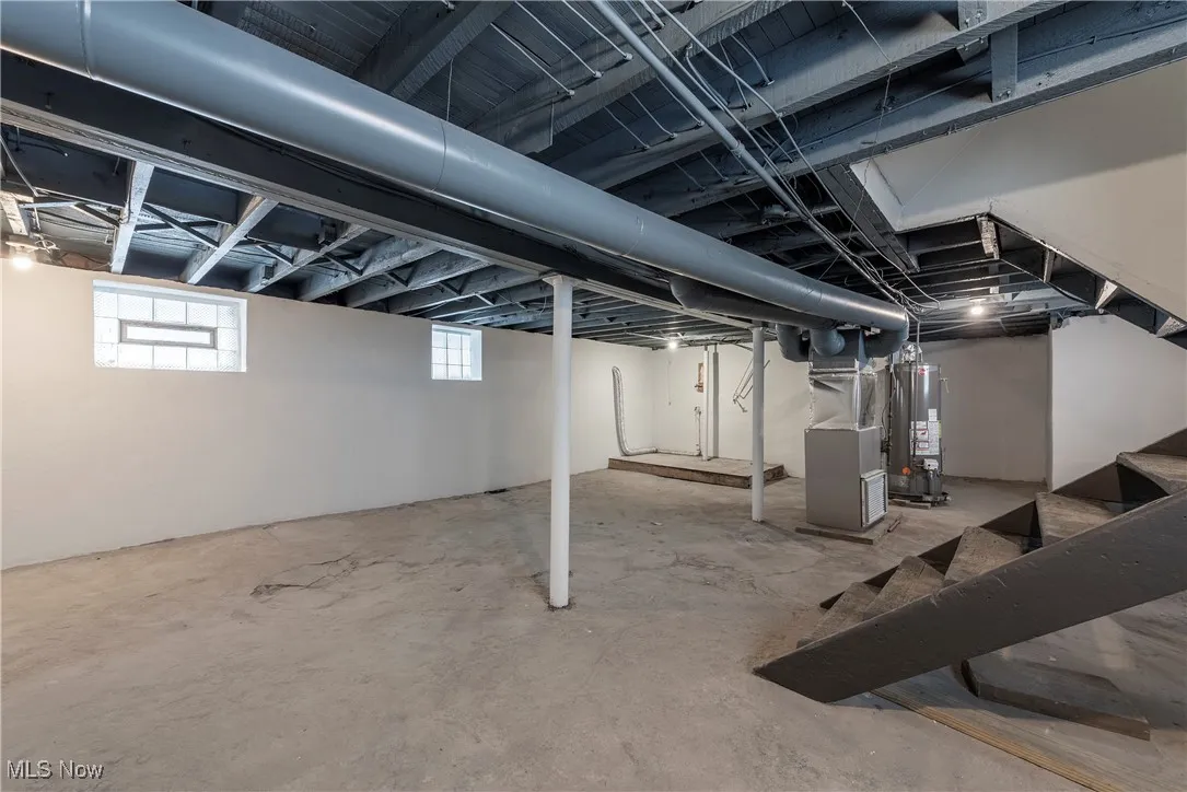 Basement featuring heating unit and water heater