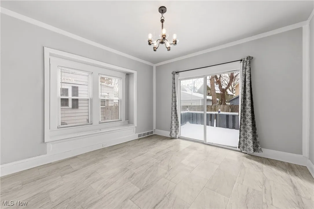 Unfurnished room with a chandelier and ornamental molding