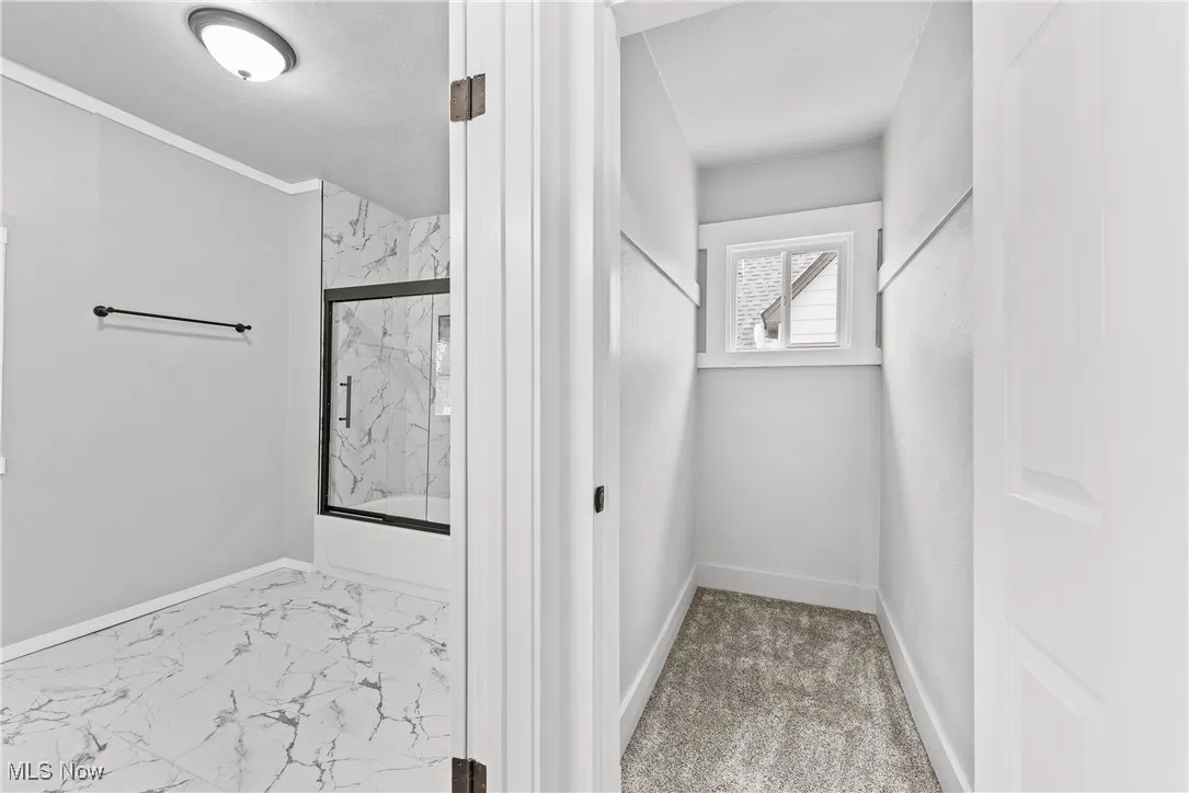 Bathroom with shower / bath combination with glass door
