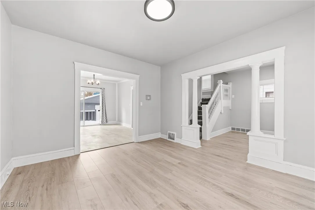Spare room with light wood-type flooring and ornate columns