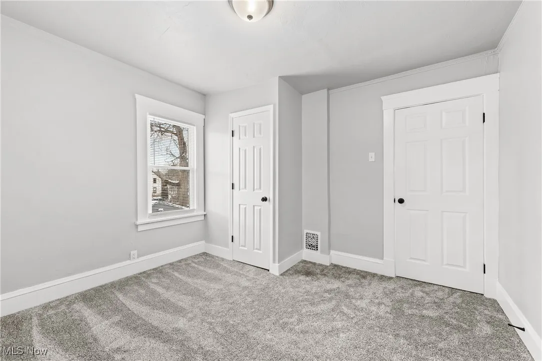 Unfurnished bedroom with light carpet
