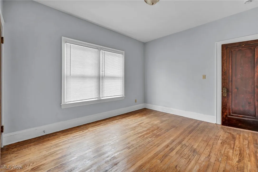 Spare room with hardwood / wood-style floors and baseboards