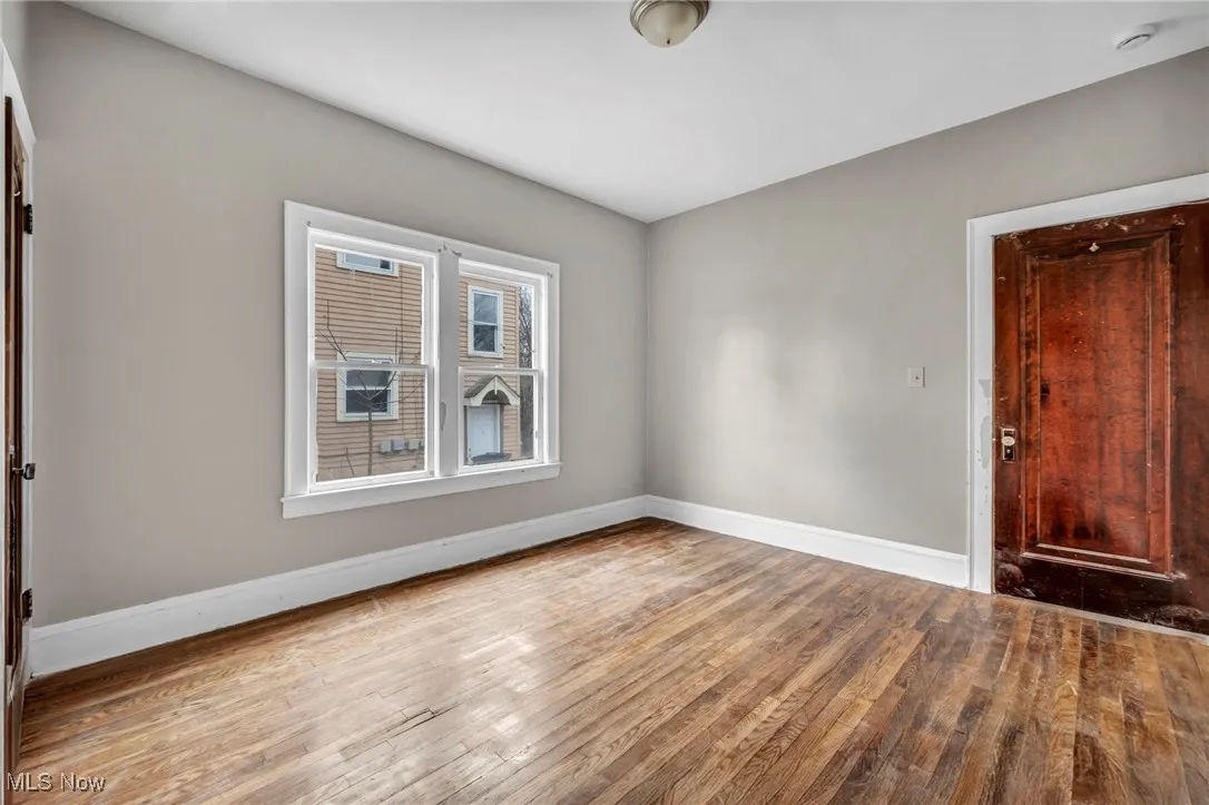 Spare room featuring hardwood / wood-style flooring and baseboards