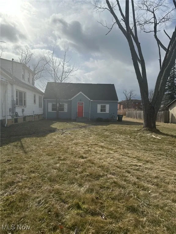 View of front of property with fence and a front lawn