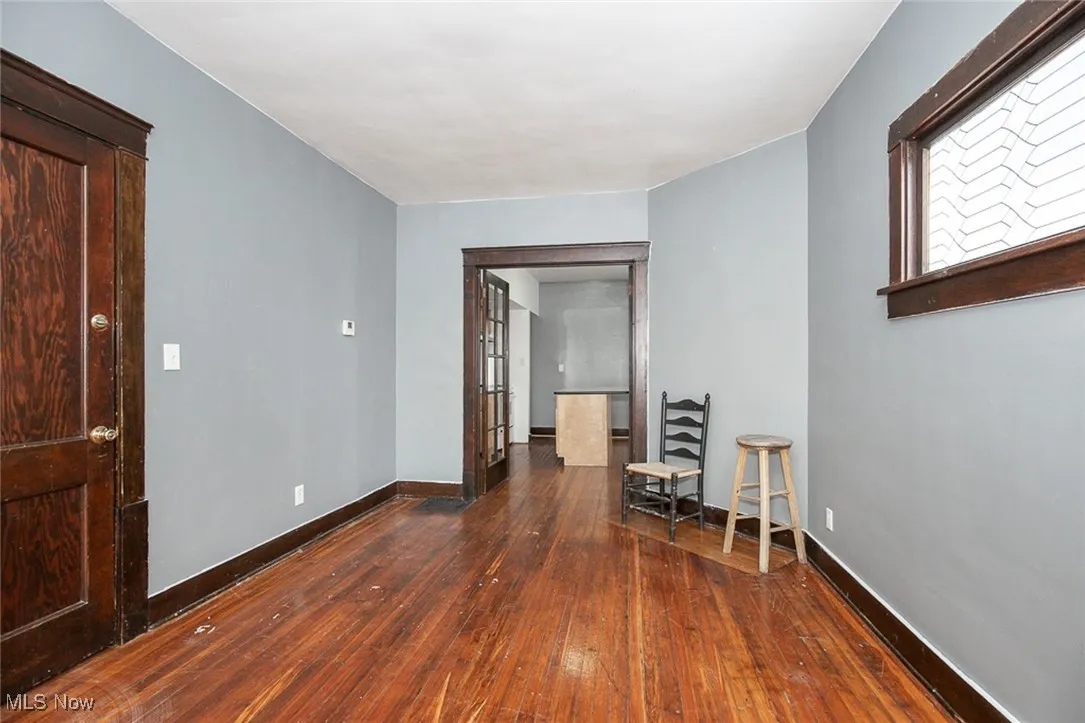Unfurnished room featuring dark wood-style floors and baseboards