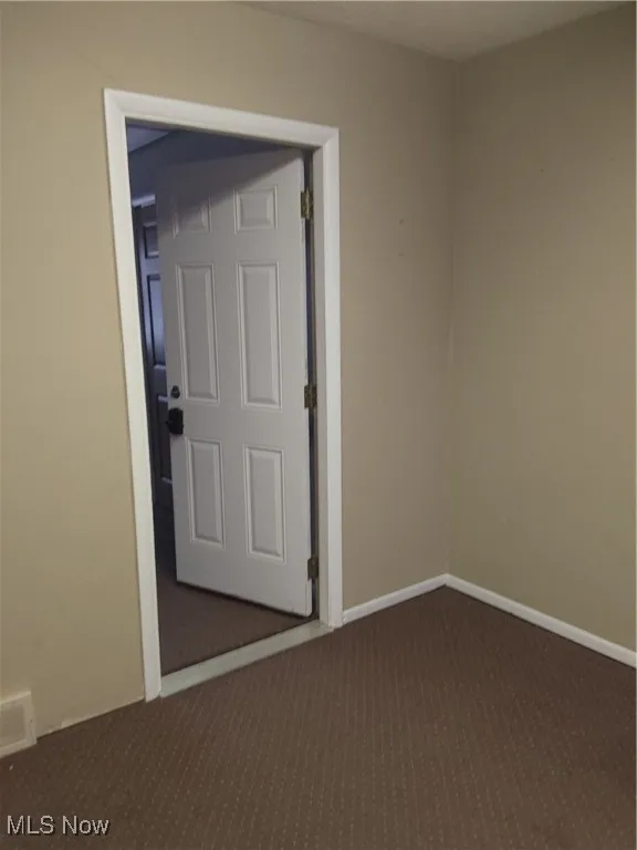 Empty room with dark colored carpet