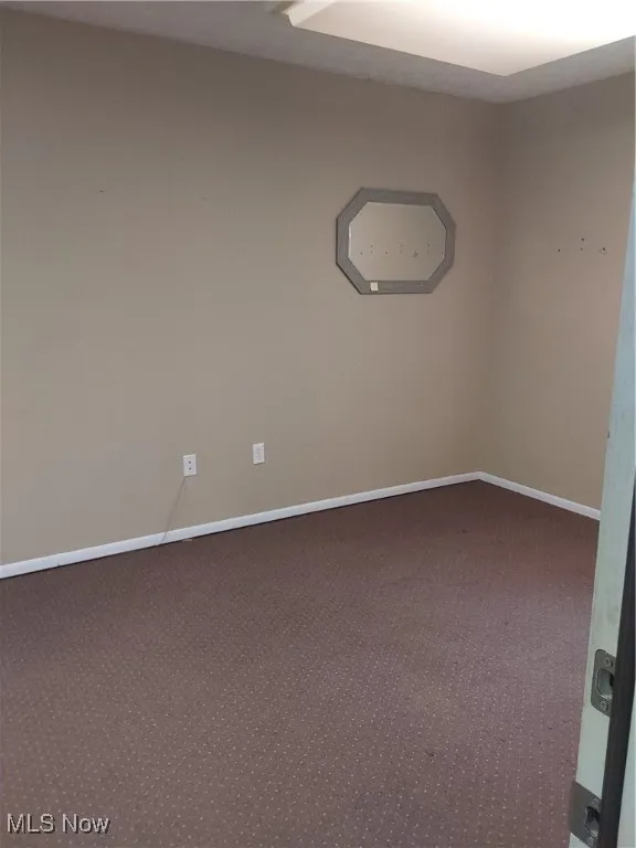 Unfurnished room featuring carpet floors and baseboards