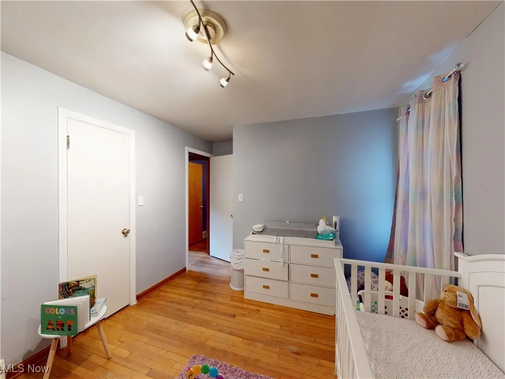 Bedroom with light wood finished floors and baseboards