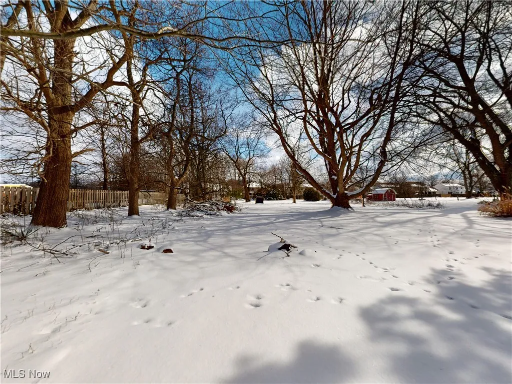 Snowy yard featuring fence