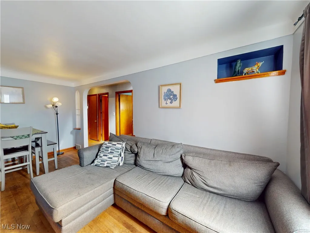 Living room with arched walkways and wood finished floors