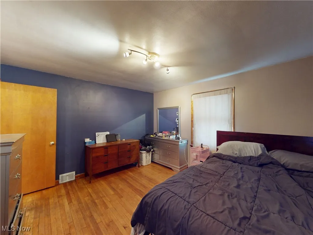 Bedroom with baseboards, visible vents, and light wood-style floors