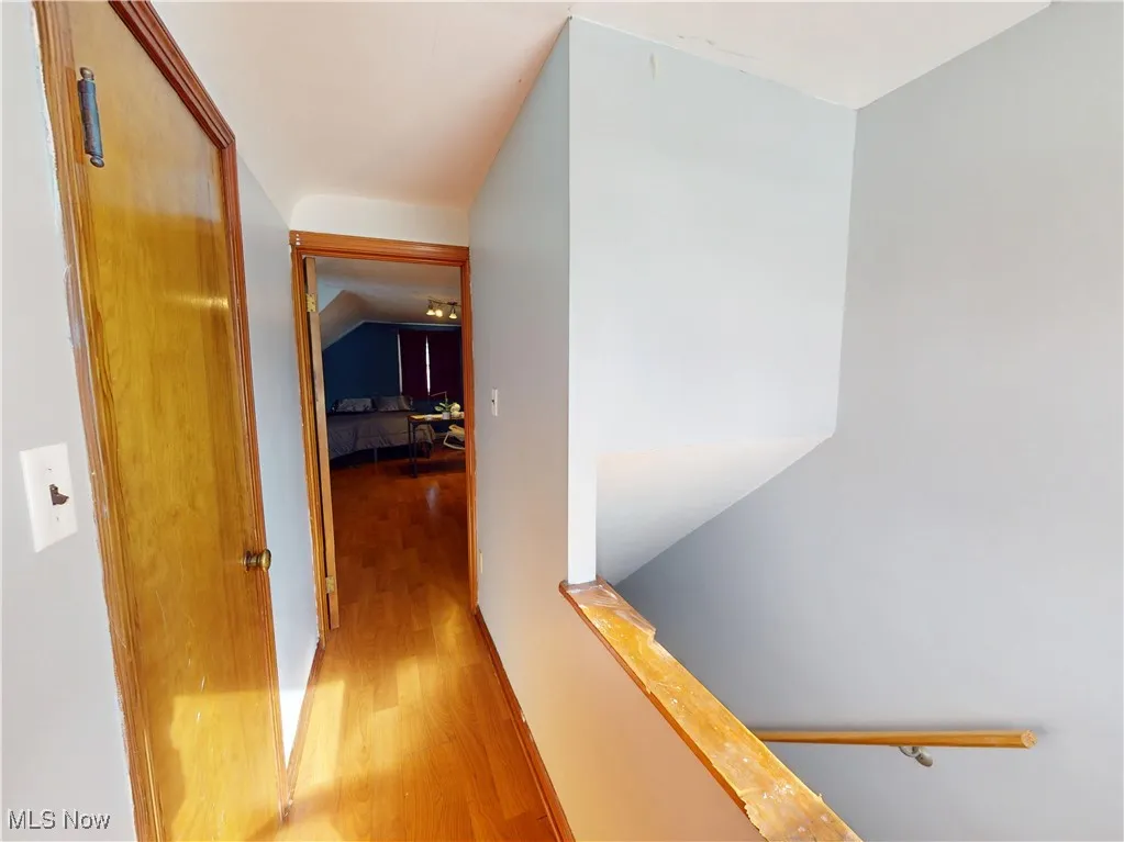 Corridor featuring light wood finished floors and an upstairs landing