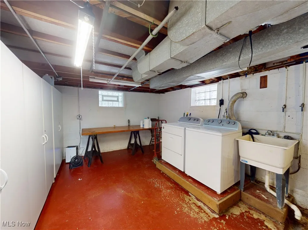 Below grade area with a healthy amount of sunlight, a sink, and washer and dryer