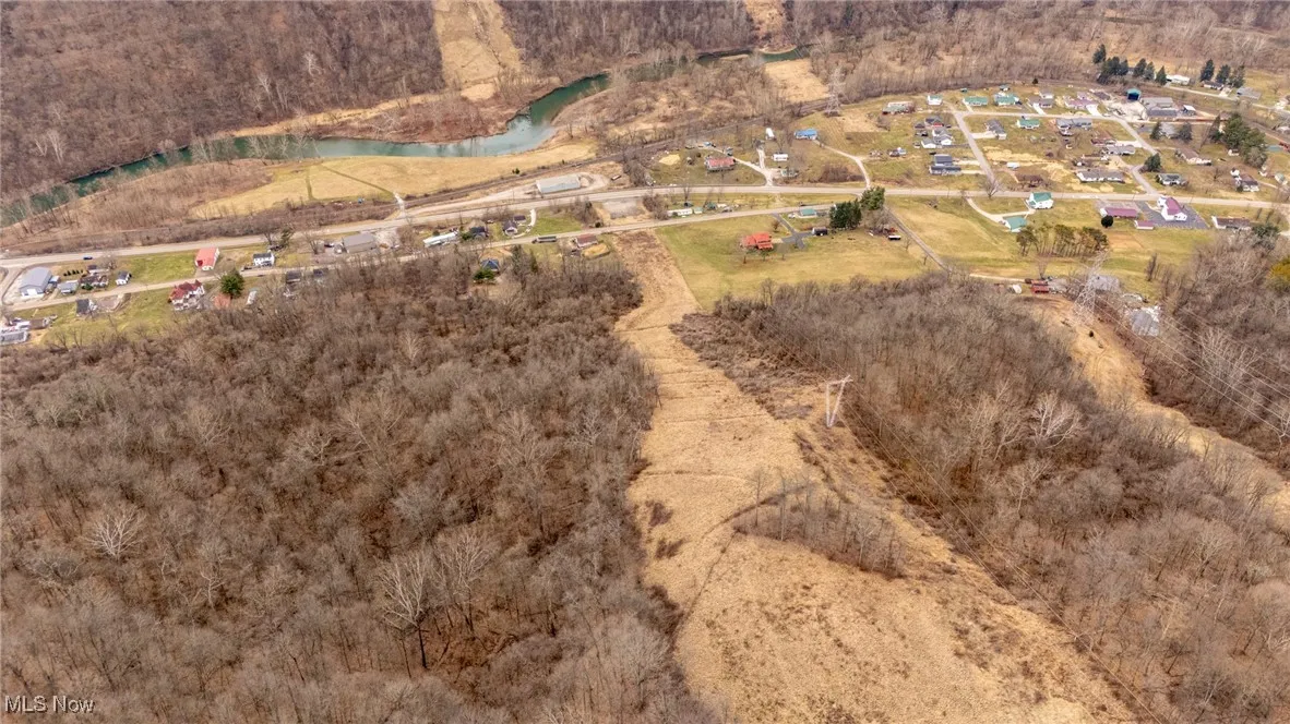 Looking down the right of way, property goes past the right strip of trees to the right behind the house below.
