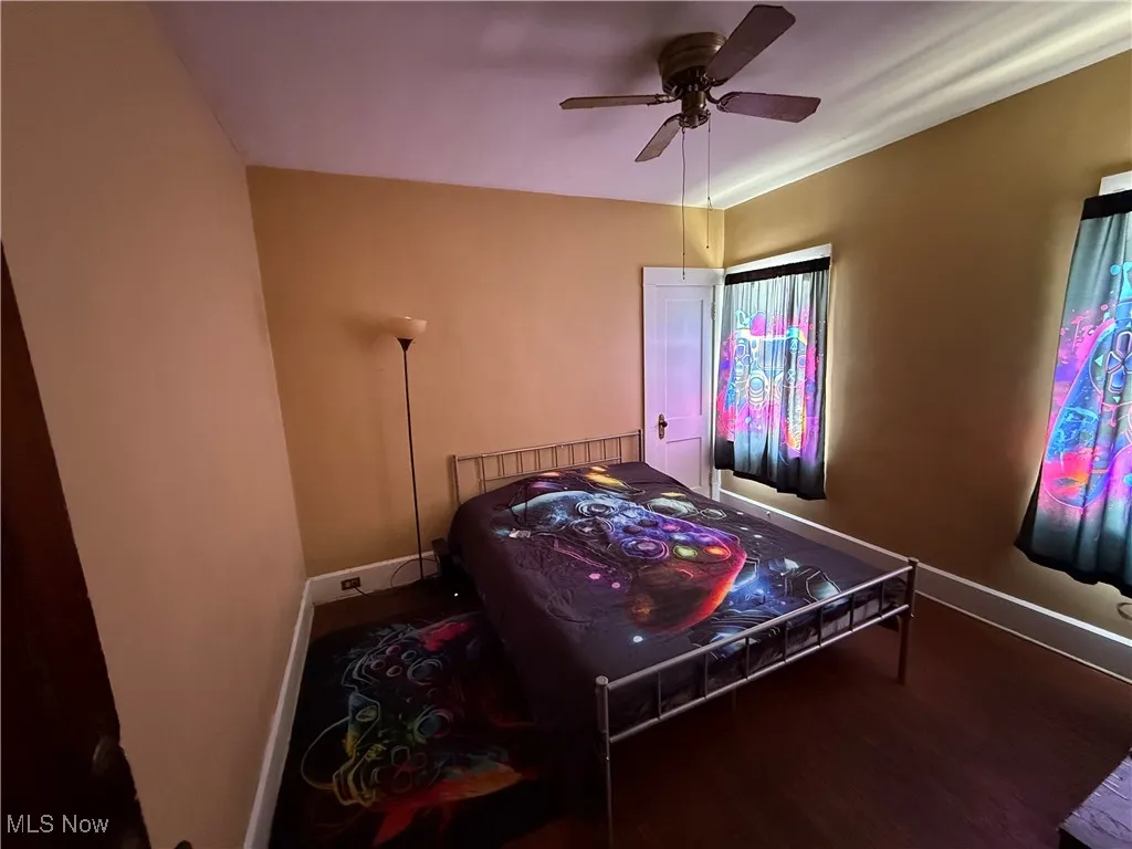 Bedroom with a ceiling fan, baseboards, and wood finished floors