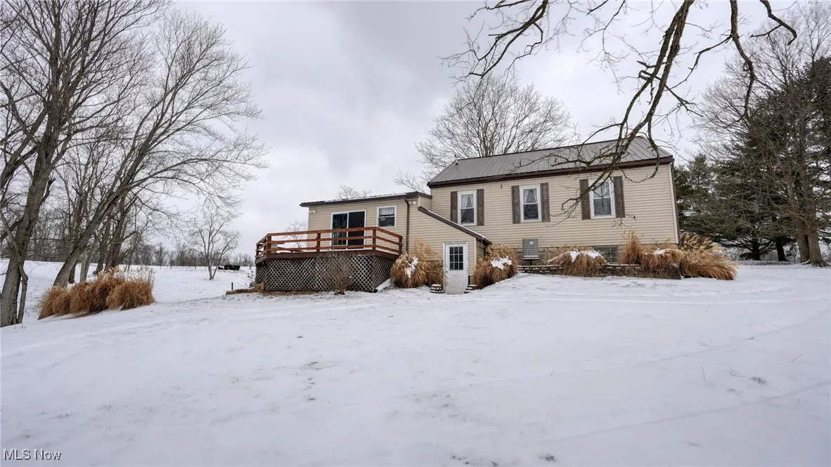 View of back of structure featuring a wooden deck