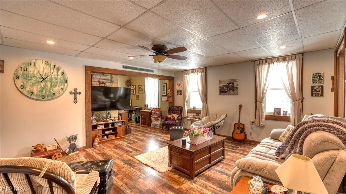 Living room featuring ceiling fan, a drop ceiling, recessed lighting, wood finished floors, and visible vents