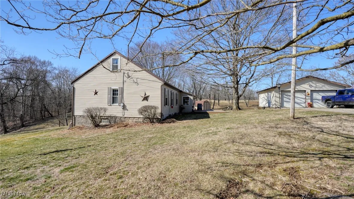View of side of home with an outbuilding, a garage, and a yard