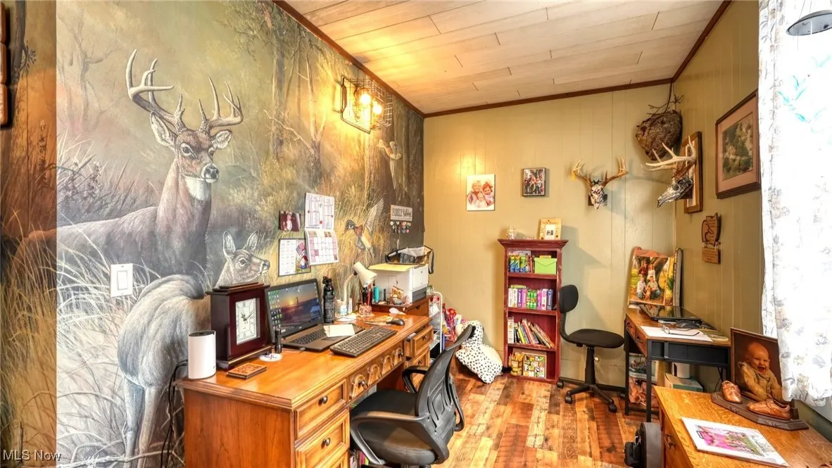 Office space featuring wood finished floors and crown molding
