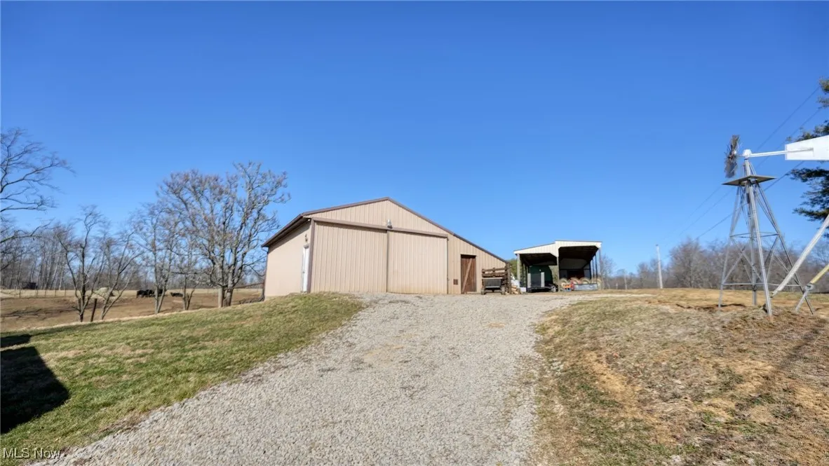 View of pole building featuring a carport and driveway