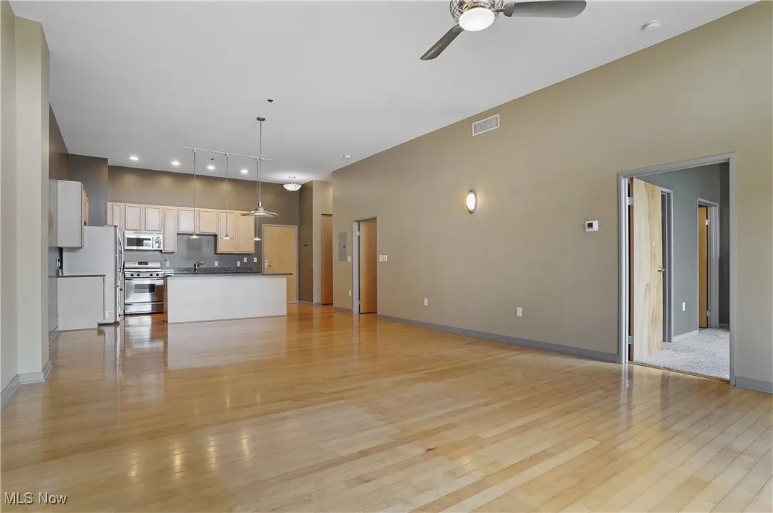 Unfurnished living room featuring a ceiling fan, light wood finished floors, and recessed lighting
