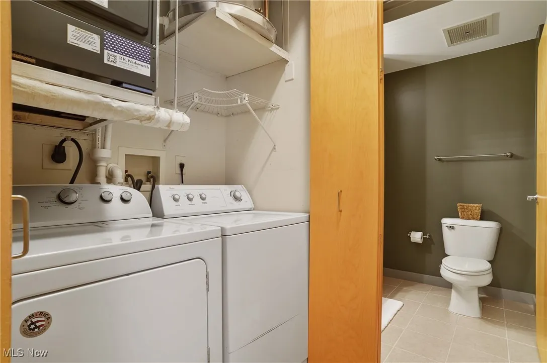 Laundry room featuring washing machine and dryer and light tile patterned flooring