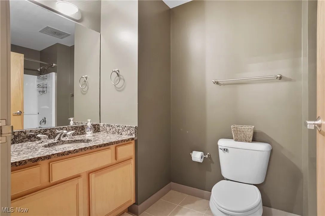 Bathroom with vanity, tile patterned flooring, and a shower