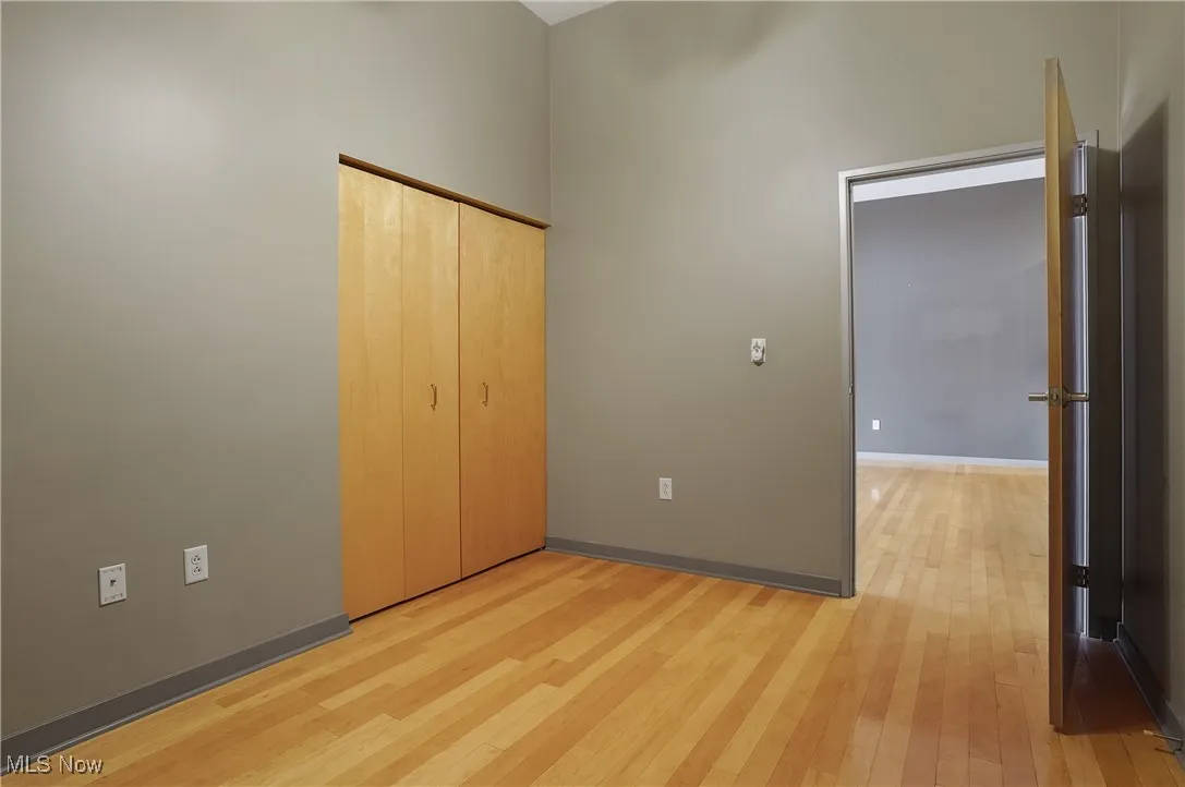 Unfurnished bedroom with light wood-type flooring and a closet