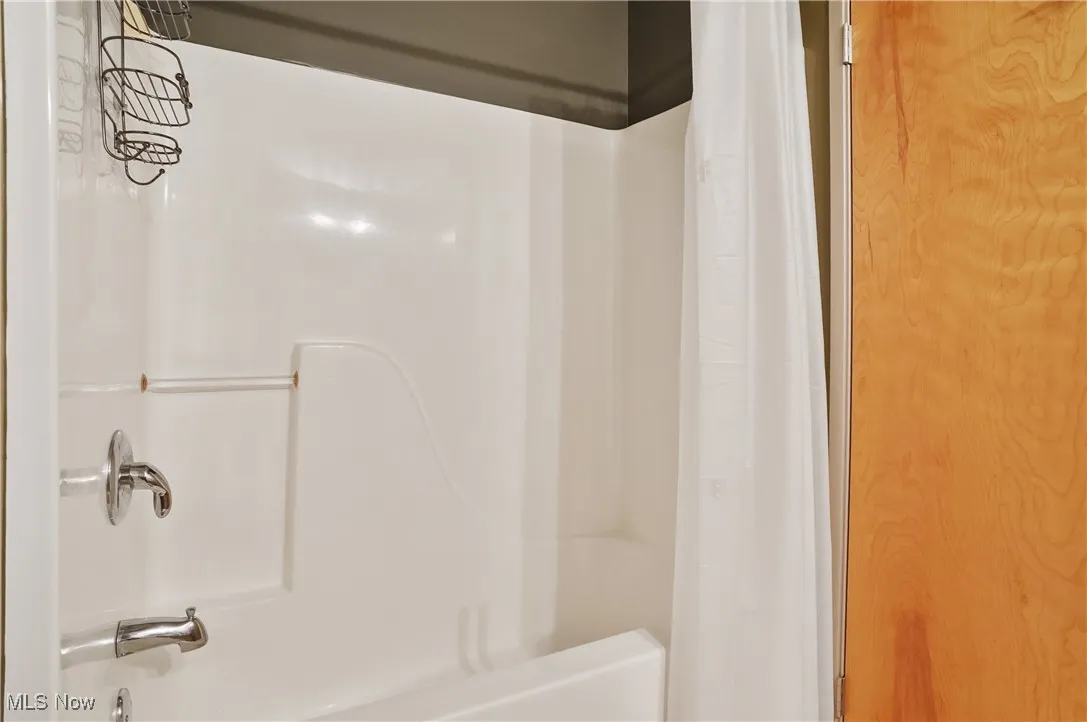 Bathroom with shower / bathtub combination with curtain