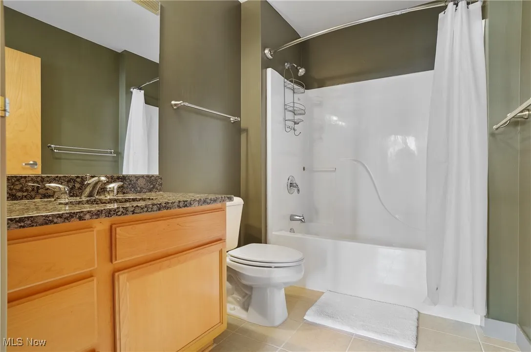 Full bath featuring tile patterned flooring, vanity, and shower / bath combo