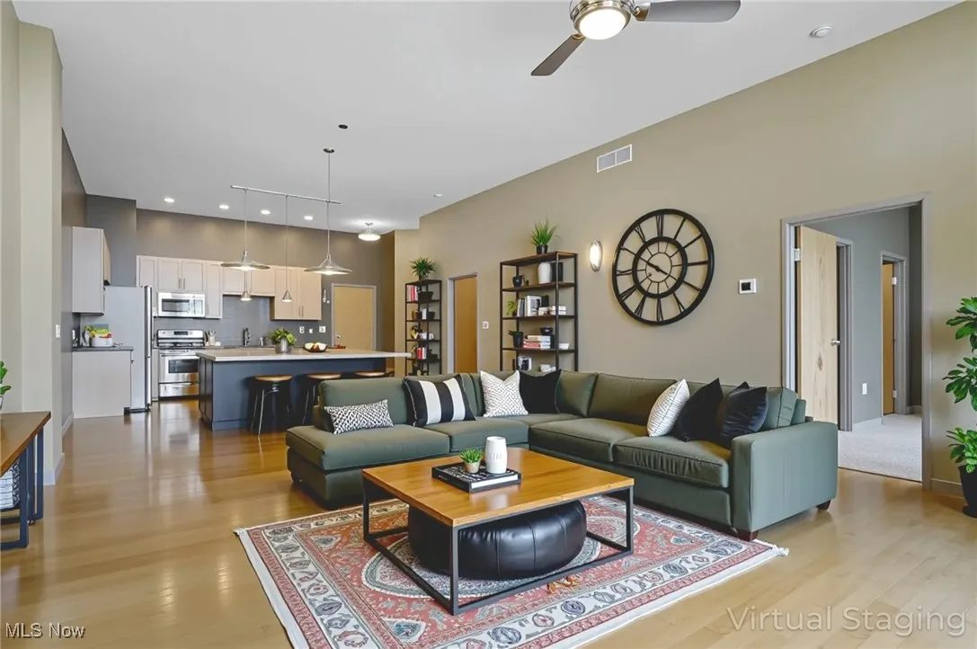 Living area with light wood-style flooring, a ceiling fan, and recessed lighting