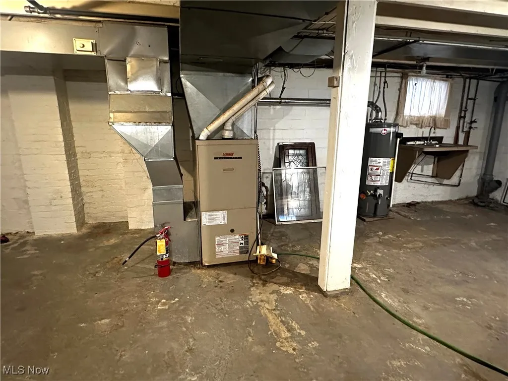 Utilities featuring water heater and a sink