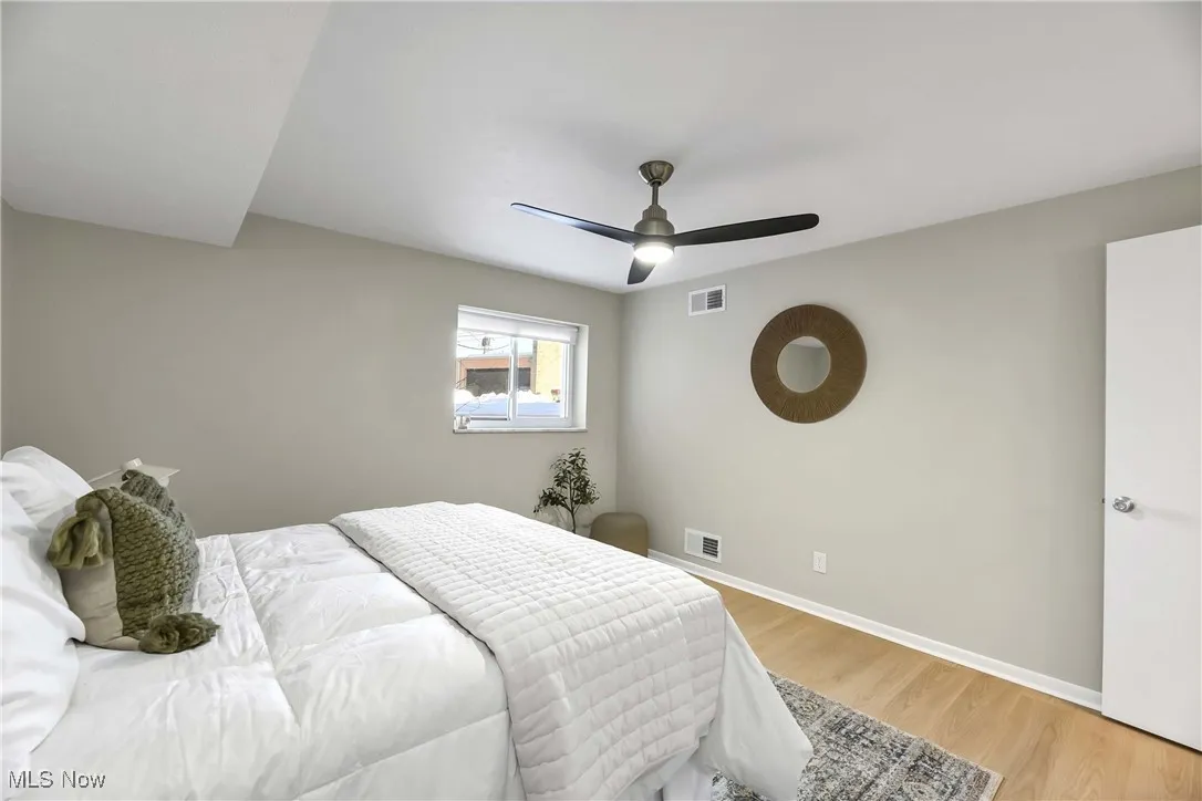 Bedroom featuring wood finished floors, visible vents, and baseboards