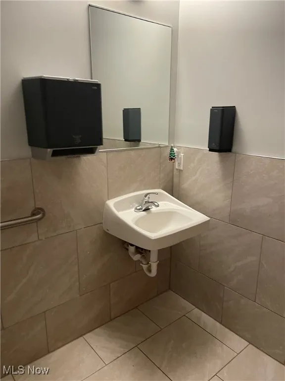 Bathroom with tile patterned floors and tile walls