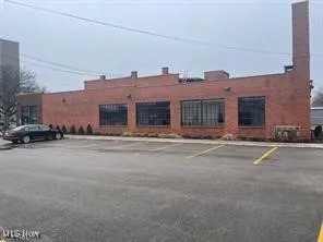 View of building exterior featuring uncovered parking