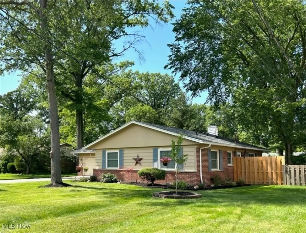 Ranch-style house with brick siding, a chimney, and a garage