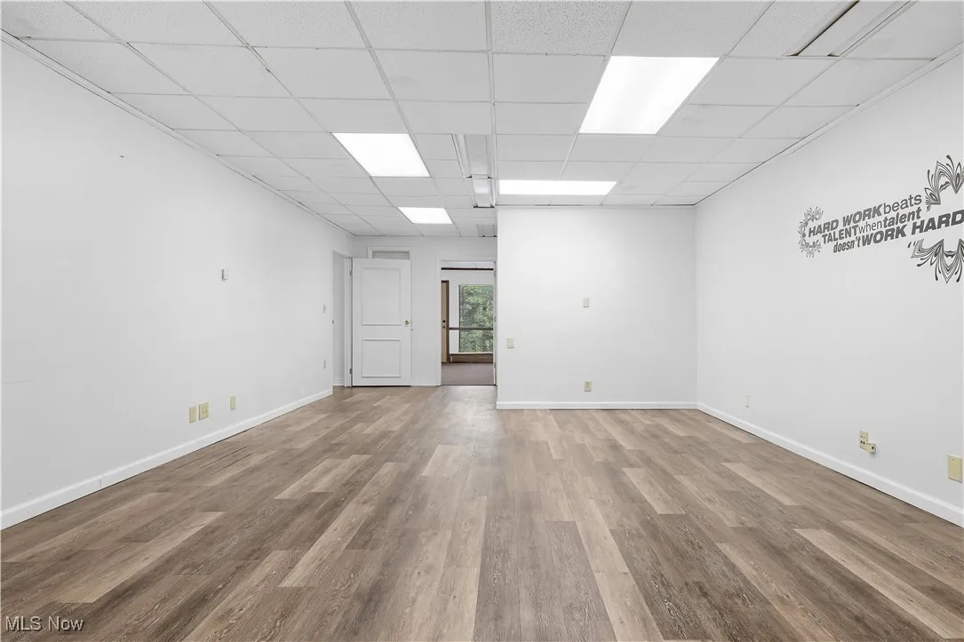 Spare room featuring wood finished floors and a paneled ceiling