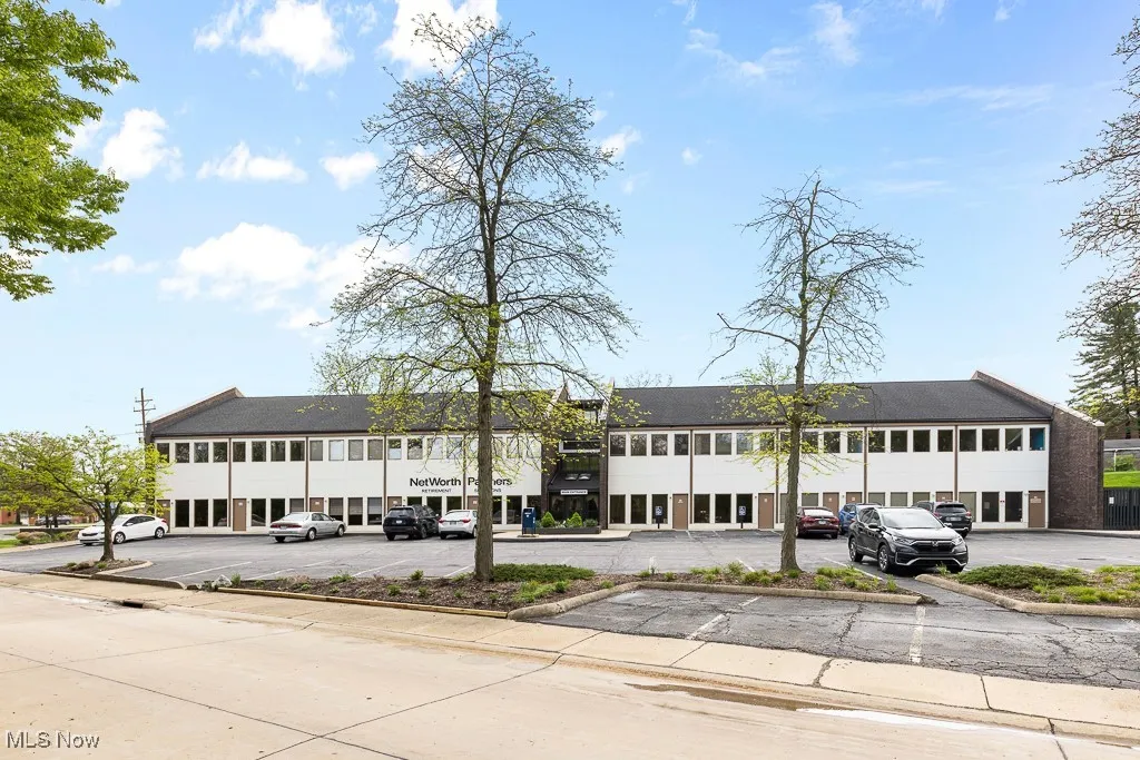 View of building exterior featuring uncovered parking