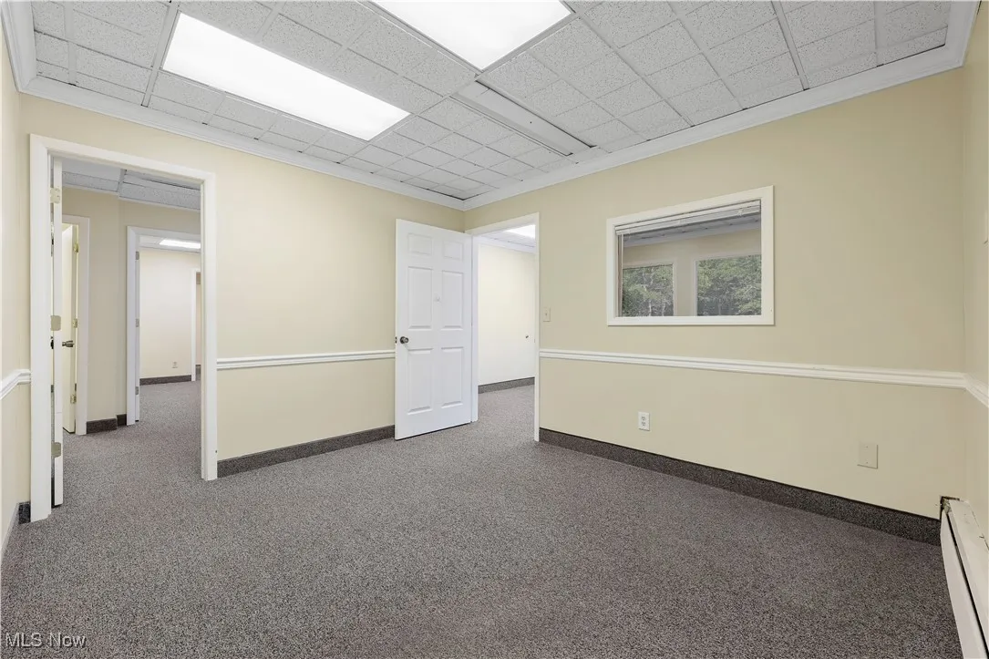 Unfurnished room featuring a baseboard radiator and carpet floors