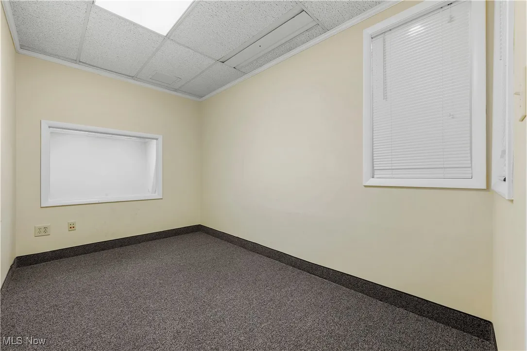 Empty room featuring baseboards and a drop ceiling