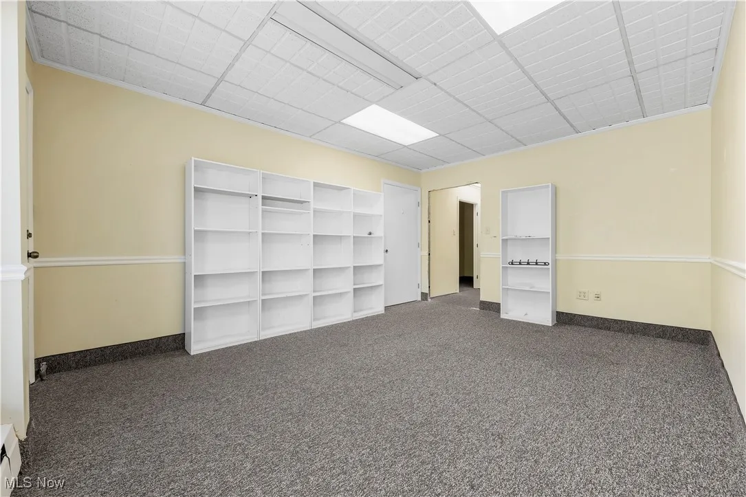 Unfurnished bedroom with carpet floors, a closet, and a paneled ceiling