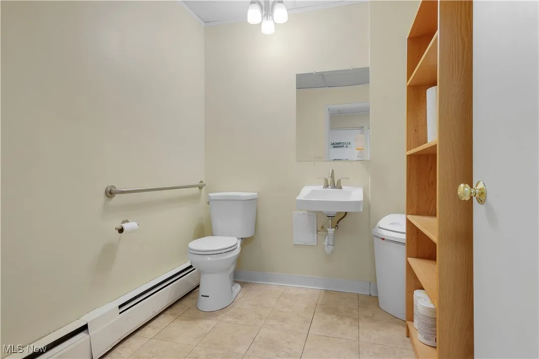 Bathroom with a baseboard radiator, tile patterned flooring, and ornamental molding