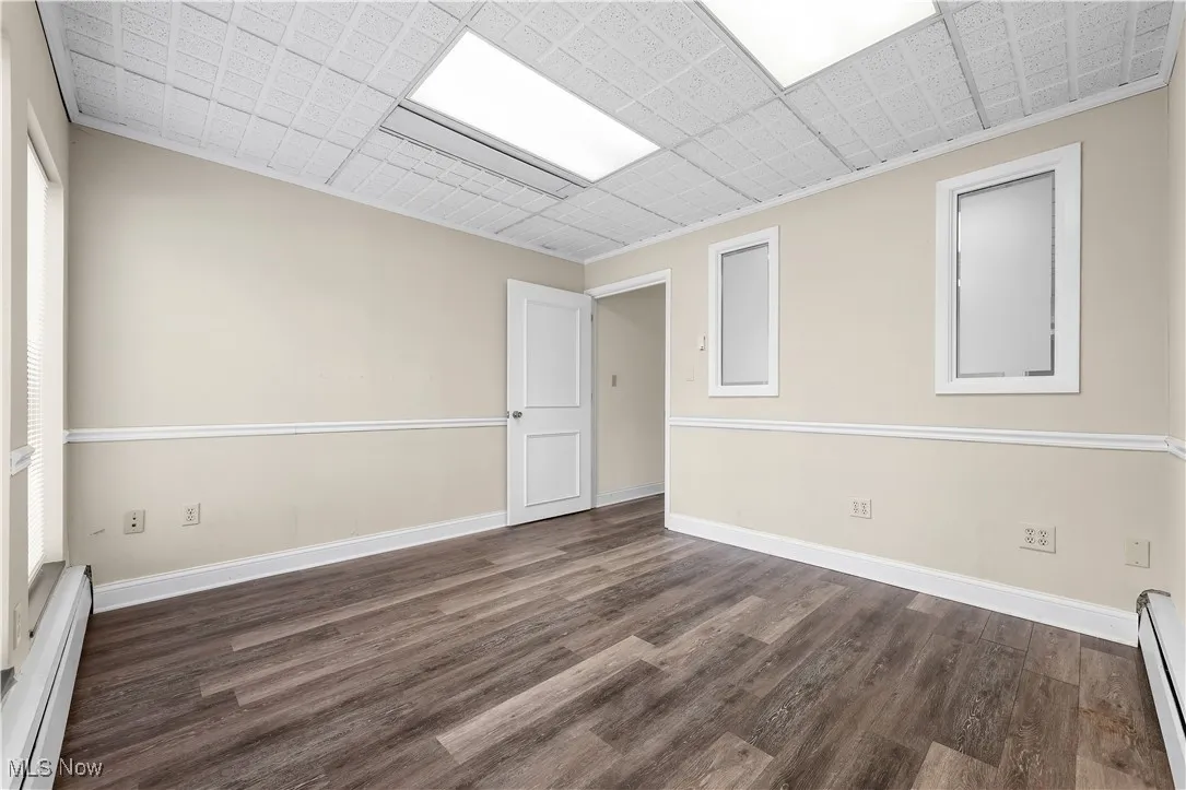 Empty room featuring a baseboard radiator and wood finished floors